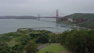 6K aerial stock footage fly over trees to reveal the Golden Gate Bridge on a foggy day, San Francisco, California Aerial Stock Footage | AX0175_0066