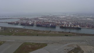 AX0175_0080 - 6K aerial stock footage of cargo ships docked at the Port of Oakland, California