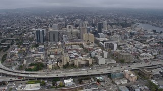 6K aerial stock footage tilt from port to approach Downtown Oakland on a foggy day, California Aerial Stock Footage | AX0175_0086