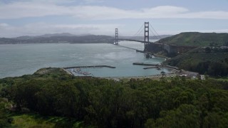 AX0175_0173 - 6K aerial stock footage fly over trees on the shore to reveal the Golden Gate Bridge, San Francisco, California