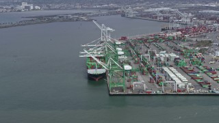 6K aerial stock footage of passing a cargo ship under cranes at the Port of Oakland, California Aerial Stock Footage | AX0175_0215