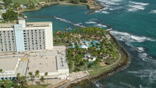 AX101_004E - 4.8K aerial stock footage of Oceanside Caribbean Resort Hotel and Pool Area, San Juan Puerto Rico