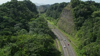 4.8K aerial stock footage Following light traffic through lush green mountains, Karst Forest, Puerto Rico Aerial Stock Footage | AX101_078E