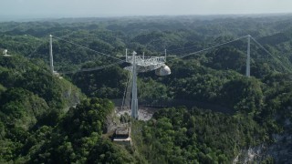 AX101_110E - 4.8K aerial stock footage Ascending over lush jungle toward Arecibo Observatory, Puerto Rico