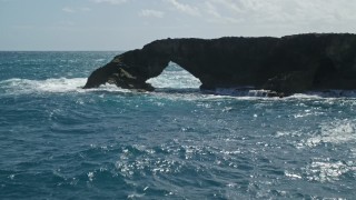 4.8K aerial stock footage of an arched rock formation in crystal blue waters, Arecibo, Puerto Rico Aerial Stock Footage | AX101_168E