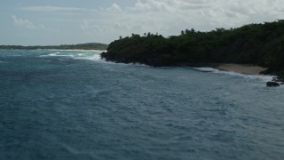 AX101_192 - 4.8K aerial stock footage of Crystal clear blue waters along a beach and lush vegetation, Manati, Puerto Rico 