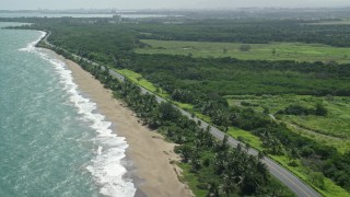 AX101_224E - 4.8K aerial stock footage of a beach and highway along the coast and blue waters, Dorado, Puerto Rico