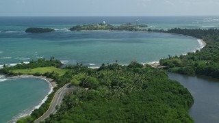 AX101_226E - 4.8K aerial stock footage of a highway following crystal blue Caribbean, revealing  Punta Salinas Radar Site, Dorado, Puerto Rico