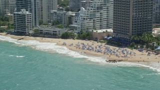 4.8K aerial stock footage of Tourists on a beach enjoying clear blue waters, San Juan, Puerto Rico Aerial Stock Footage | AX102_004