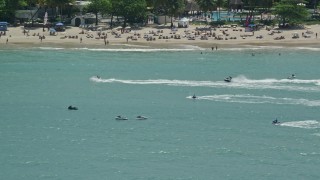 AX102_009 - 4.8K aerial stock footage of Jet skiers along the beach in crystal blue water, Carolina, Puerto Rico