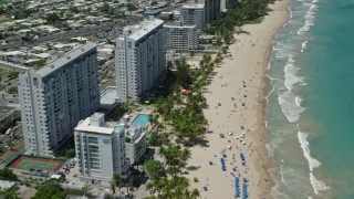 4.8K aerial stock footage of Hotels and apartment buildings along the beach and clear turquoise waters, Carolina, San Juan  Aerial Stock Footage | AX102_011