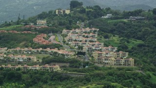 AX102_044E - 4.8K aerial stock footage of condos on a tree covered hillside, Rio Grande, Puerto Rico