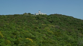 AX102_060E - 4.8K aerial stock footage Flying over crystal clear blue water toward forest and Cape San Juan Light, Puerto Rico