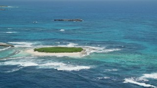 4.8K aerial stock footage of Tiny green island in tropical blue waters, Puerto Rico Aerial Stock Footage | AX102_086