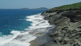 AX102_126E - 4.8K aerial stock footage of sapphire blue waters along a rugged coast, Culebra, Puerto Rico