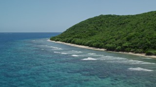 4.8K aerial stock footage of sapphire blue waters along a lush green coast, Culebra, Puerto Rico Aerial Stock Footage | AX102_133E