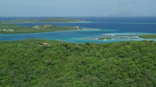 AX102_170E - 4.8K aerial stock footage of hillside homes and lush vegetation on the coast near sapphire blue waters, Culebra, Puerto Rico