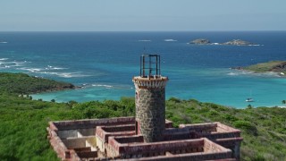 AX102_176E - 4.8K aerial stock footage fly over hilly coast toward Culebrita Lighthouse, Puerto Rico