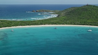 AX102_182E - 4.8K aerial stock footage of catamarans in turquoise blue waters along a white sand Caribbean beach, Culebrita, Puerto Rico