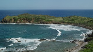 AX102_190E - 4.8K aerial stock footage of waves rolling in toward the coast, Culebrita, Puerto Rico