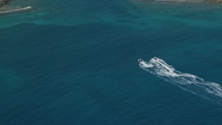 4.8K aerial stock footage of Jet skiers in sapphire waters to reveal coastal town, Charlotte Amalie, St. Thomas Aerial Stock Footage | AX102_206