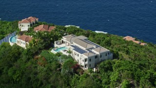 AX102_285E - 4.8K aerial stock footage of hilltop mansions looking out toward sapphire blue Caribbean waters, Magens Bay, St Thomas