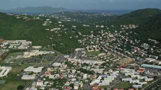 AX103_006 - 4.8K aerial stock footage of Hillside homes among trees near the coast, Charlotte Amalie, St Thomas