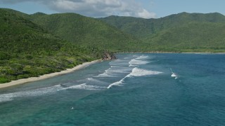 4.8K aerial stock footage of a Caribbean beach along sapphire blue waters and tree covered hills, Reef Bay, St John Aerial Stock Footage | AX103_044E