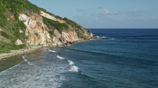 4.8K aerial stock footage flying low by a Caribbean beach and sapphire blue waters cliffside, Reef Bay, St John Aerial Stock Footage | AX103_048E