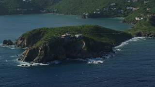 AX103_059 - 4.8K aerial stock footage of cliff top mansion along Caribbean blue waters, Cruz Bay, St John