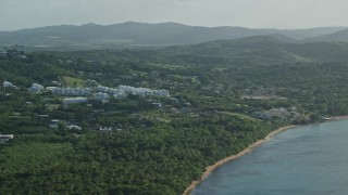 AX103_117 - 4.8K aerial stock footage of Condominiums nestled in trees with views of Caribbean blue waters, Fajardo, Puerto Rico