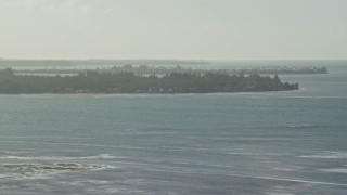 AX103_124E - 4.8K aerial stock footage fly over Caribbean blue waters toward the coast of an island, Rio Grande, Puerto Rico