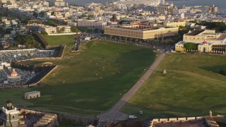 AX104_018 - 4.8K aerial stock footage of Cementerio Santa María Magdalena de Pazzis, Fort San Felipe del Morro, Old San Juan, sunset