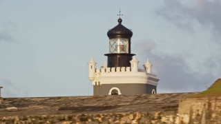 4.8K aerial stock footage of Port San Juan Light and Fort San Felipe del Morro, Old San Juan, sunset Aerial Stock Footage | AX104_023E