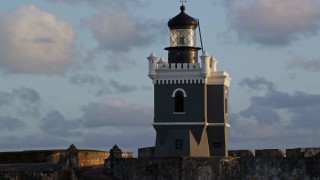 4.8K aerial stock footage of Port San Juan Light atop Fort San Felipe del Morro, Old San Juan, sunset Aerial Stock Footage | AX104_026E