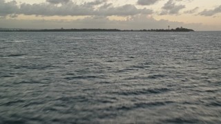 AX104_093E - 4.8K aerial stock footage flying over the waters toward Toa Baja, Puerto Rico, twilight