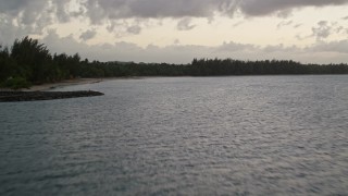 AX104_111 - 4.8K aerial stock footage of a Caribbean beach along ocean blue waters, Dorado, Puerto Rico, sunset