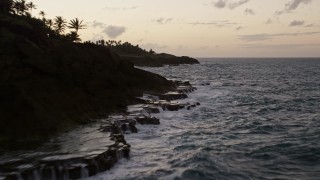 AX104_116E - 4.8K aerial stock footage fly low over the ocean along Caribbean coastline, Dorado, Puerto Rico, twilight