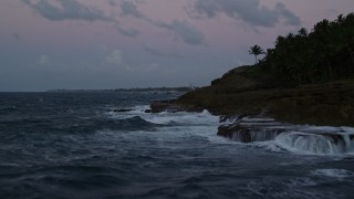 AX104_125E - 4.8K aerial stock footage of the ocean along rugged Caribbean coast, Dorado, Puerto Rico, twilight