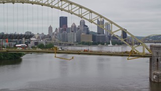 AX105_159E - 4.8K aerial stock footage flying over bridge toward skyline, Downtown Pittsburgh, Pennsylvania