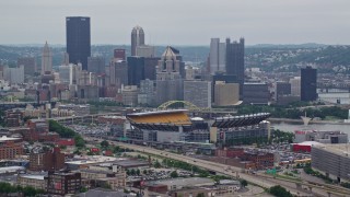 AX105_225E - 4.8K aerial stock footage of Heinz Field Football Stadium and Downtown Pittsburgh Skyline, Pennsylvania