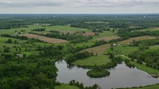 4.8K aerial stock footage flying over pond and farmland in Enon Valley, Pennsylvania Aerial Stock Footage | AX106_061E