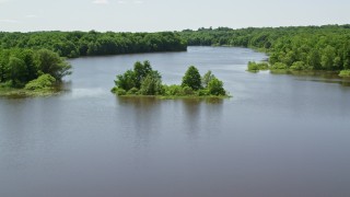 AX106_157E - 4.8K aerial stock footage of a tiny Island with trees in Akron City Reservoir, Chagrin Falls