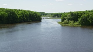 AX106_159E - 4.8K aerial stock footage of a low altitude flight over the Akron City Reservoir, reveal small bridge, Chagrin Falls, Ohio