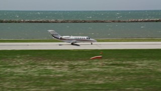 AX106_269 - 4.8K aerial stock footage tracking Private Jet Taking Off from Cleveland Burke Lakefront Airport, Ohio