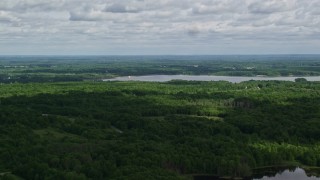 4.8K aerial stock footage flying over forest toward a reservoir, Ravenna, Ohio Aerial Stock Footage | AX107_092E