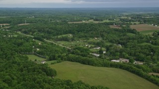 4.8K aerial stock footage flying over forests toward rural homes, East Palestine, Ohio Aerial Stock Footage | AX107_111E