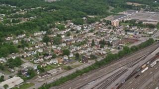 AX107_140E - 4.8K aerial stock footage of homes near a rail yard, Conway, Pennsylvania