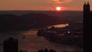 4K aerial stock footage setting sun seen while flying by skyscrapers, reveal West End Bridge, Pittsburgh, Pennsylvania, sunset Aerial Stock Footage | AX108_061E