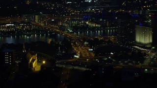 4K aerial stock footage of Point State Park and skyscrapers seen from church, Downtown Pittsburgh, Pennsylvania, night Aerial Stock Footage | AX108_197E